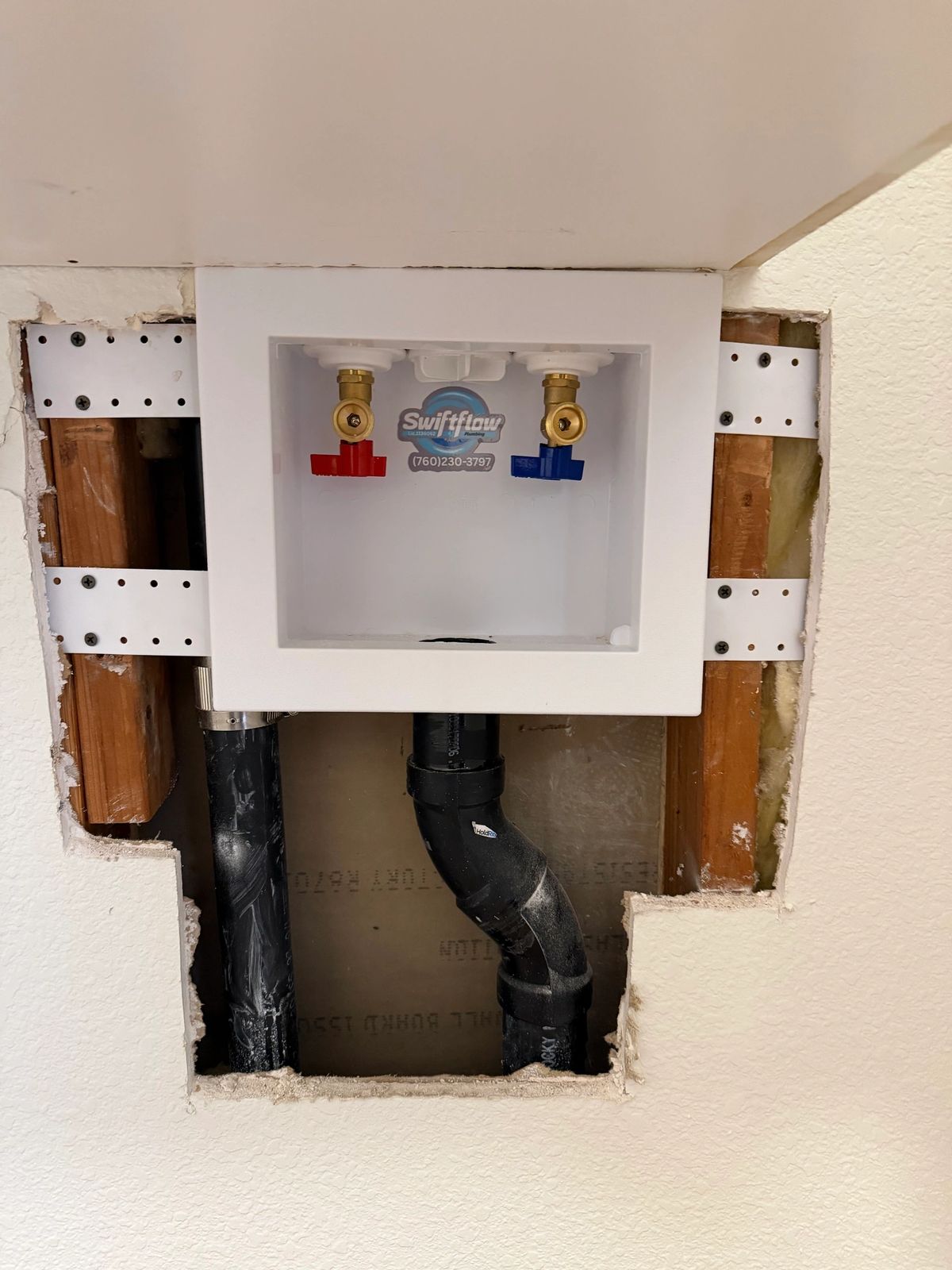 Swift Flow Plumbing branded washing machine outlet box installed in a wall